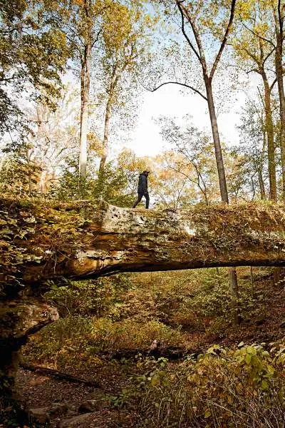 Une personne marchant le long du pont naturel de Pomona dans la forêt nationale de Shawnee.