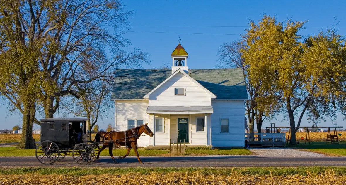 Voiture à cheval passant devant un bâtiment Amish 