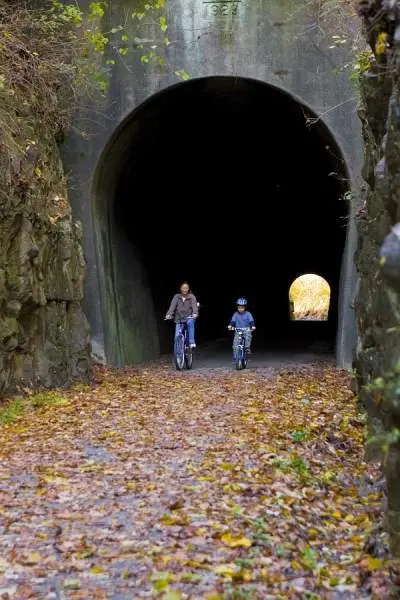 Mère et fils traversant un tunnel à vélo