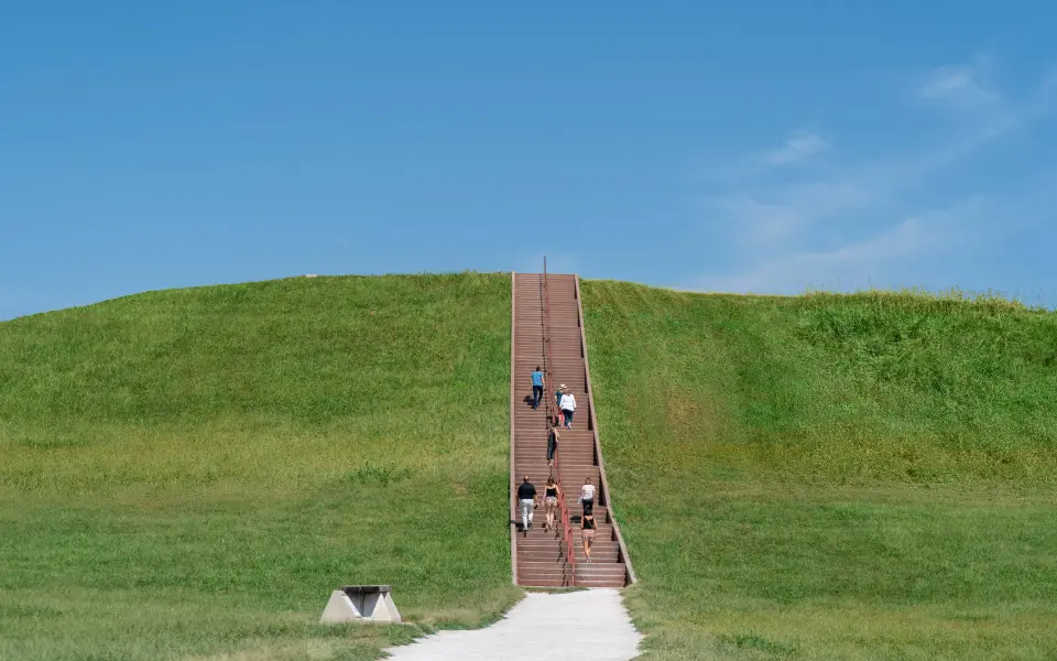 Des personnes montent les escaliers menant au sommet des Cahokia Mounds