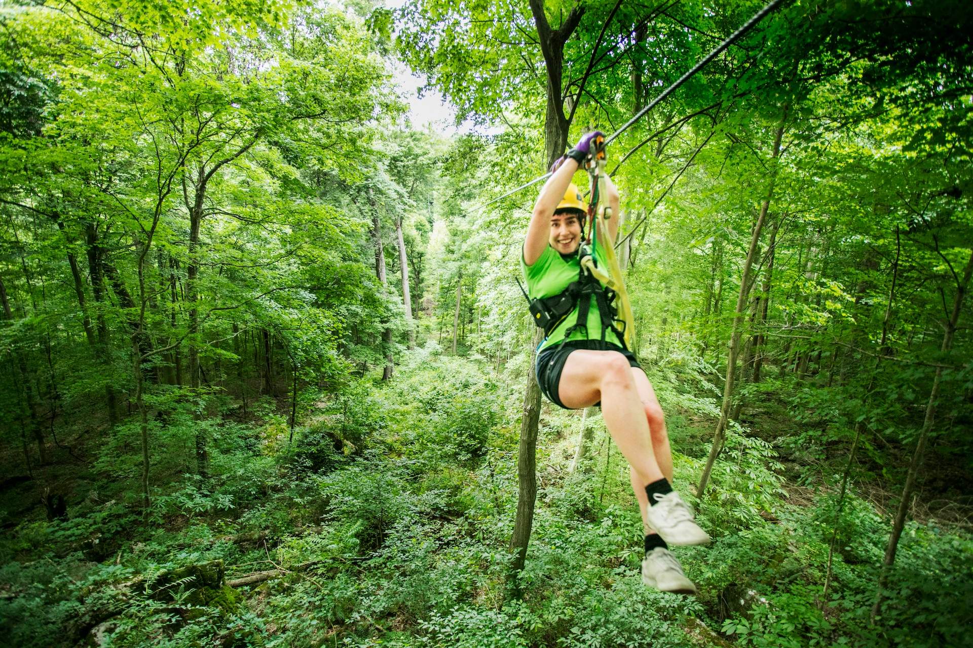 Une femme glissant le long d'une ligne d'un renard volant au milieu des arbres