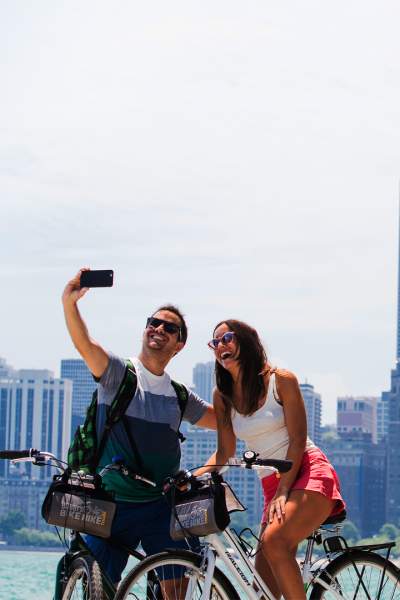 Un couple fait du vélo et prend une photo le long du front de mer de Chicago.