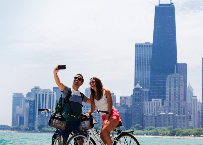 Un couple fait du vélo et prend une photo le long du front de mer de Chicago.
