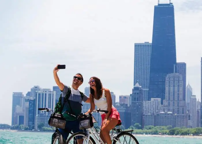 Un couple fait du vélo et prend une photo le long du front de mer de Chicago.