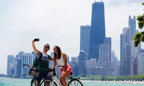 Un couple fait du vélo et prend une photo le long du front de mer de Chicago.