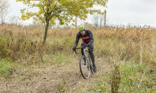 Un cycliste à travers des herbes hautes