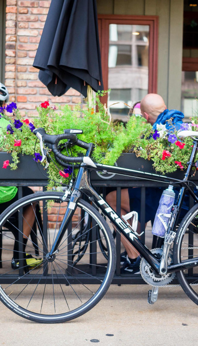 Des cyclistes prennent un café et leurs vélos sont garés à l'extérieur du café.