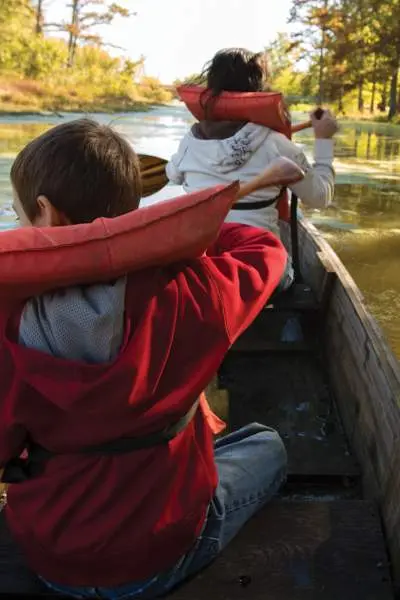 Une famille avec des gilets de sauvetage sur une rivière en canoë-kayak