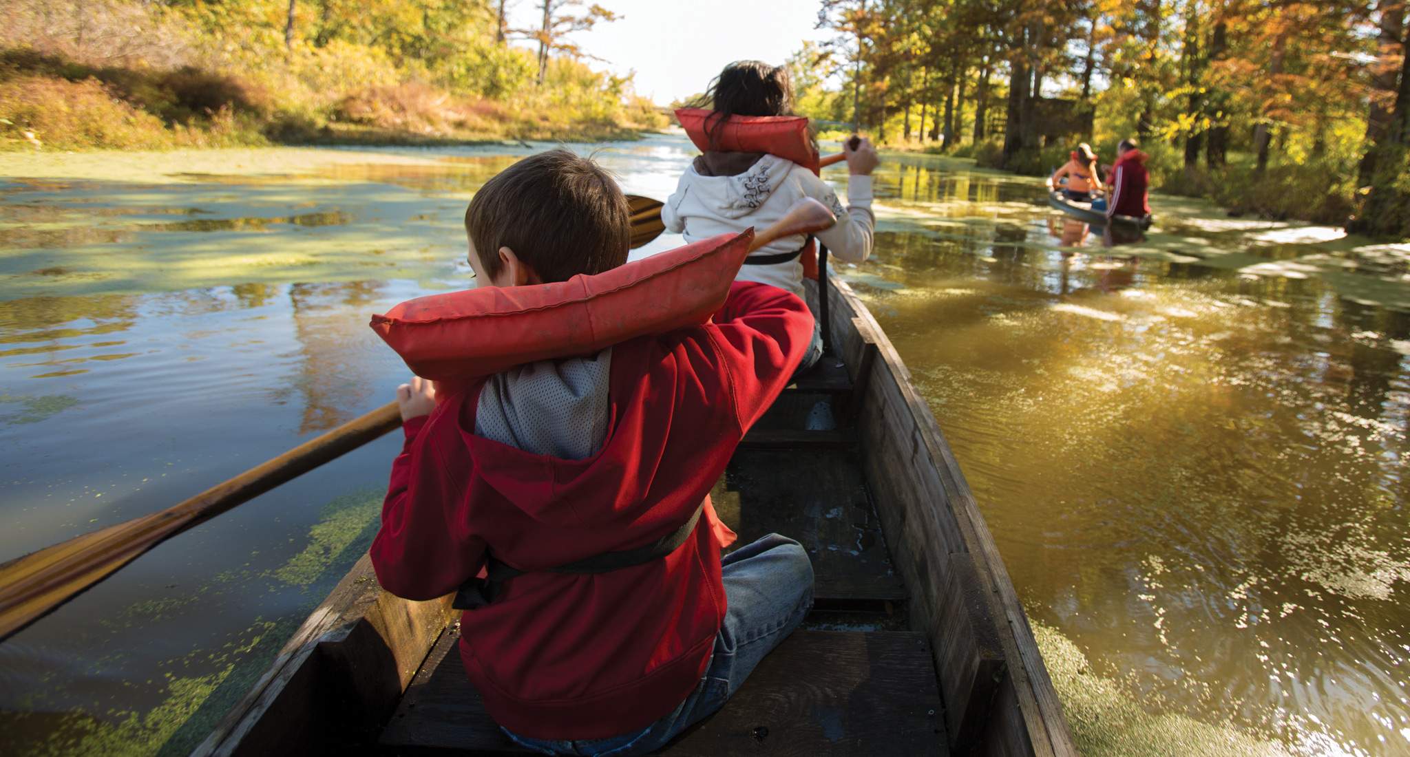 Une famille avec des gilets de sauvetage sur une rivière en canoë-kayak