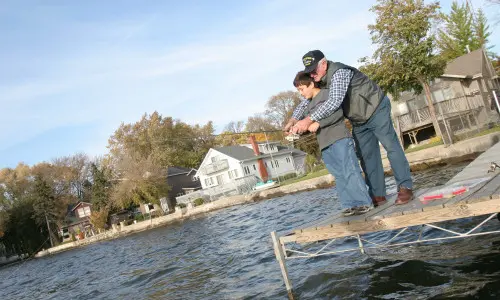 Un grand-père et un enfant en train de pêcher 