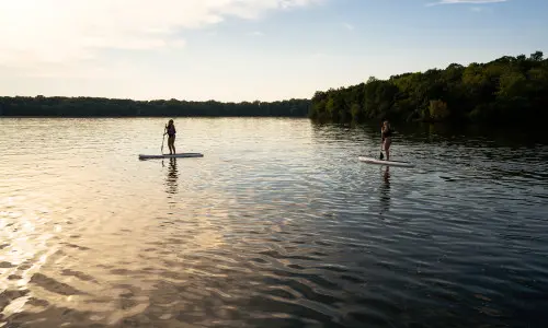 Deux personnes faisant du paddle-board sur un lac