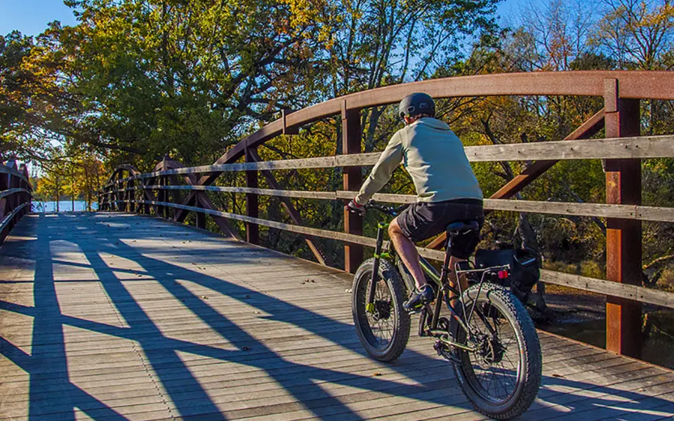 Personne passant à vélo sur le pont de la réserve forestière d'Independence Grove 