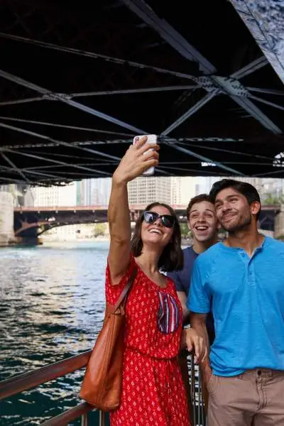 Personnes posant pour une photo au bord de la rivière sous un pont 