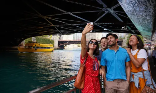 Personnes posant pour une photo au bord de la rivière sous un pont 
