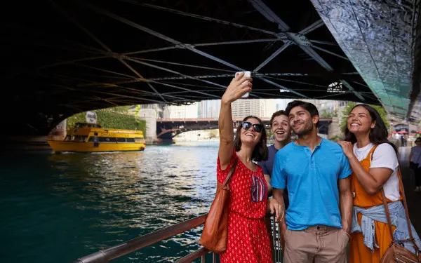 Personnes posant pour une photo au bord de la rivière sous un pont 