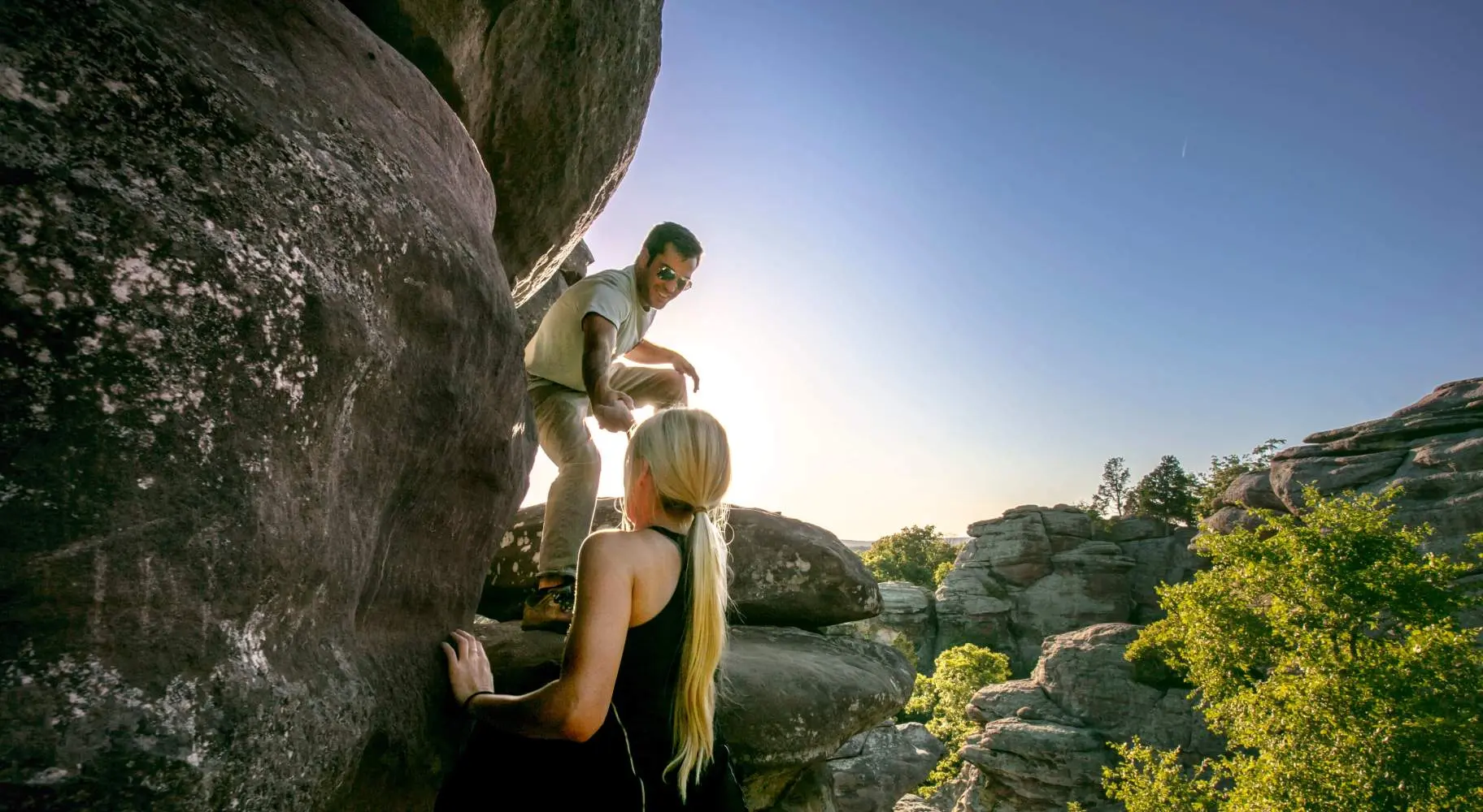 Deux personnes grimpant sur de gros rochers
