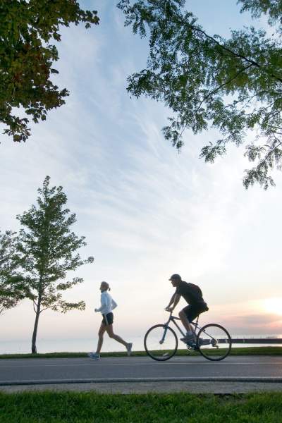Personne courant et personne faisant du vélo le long de la piste cyclable du bord du lac à Chicago
