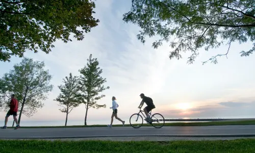 Personne courant et personne faisant du vélo le long de la piste cyclable du bord du lac à Chicago