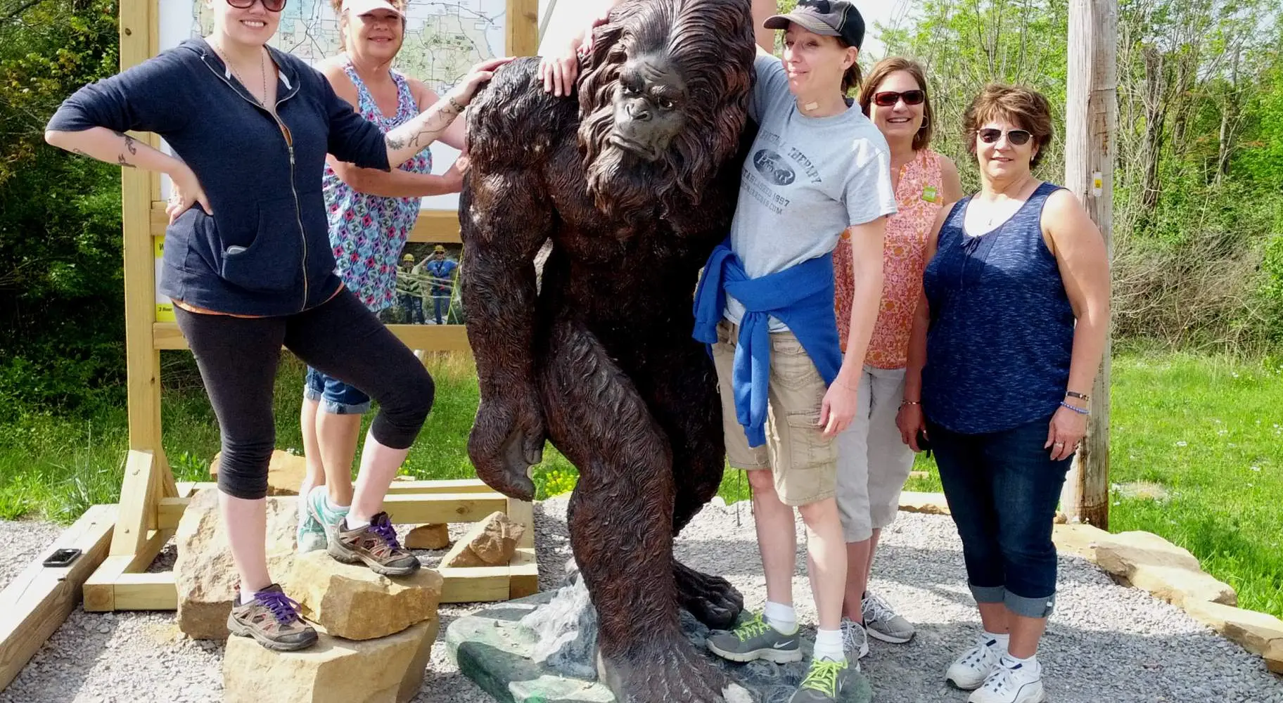 Un groupe de six femmes posant avec la statue d'un sasquatch nommé Sassy.