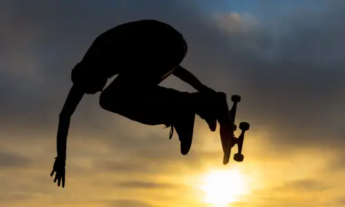 Un skateur saute en l'air au soleil couchant dans un skate park de Chicago.