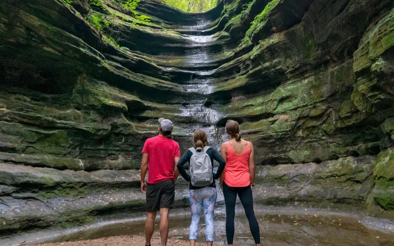 Trois personnes regardant une cascade