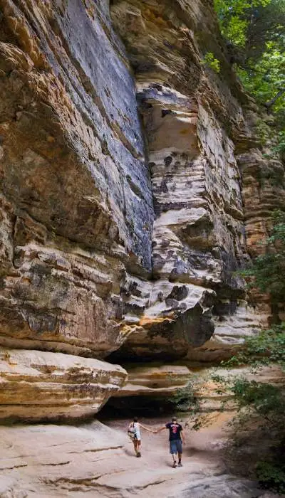 Un couple marchant à côté d'un rocher massif