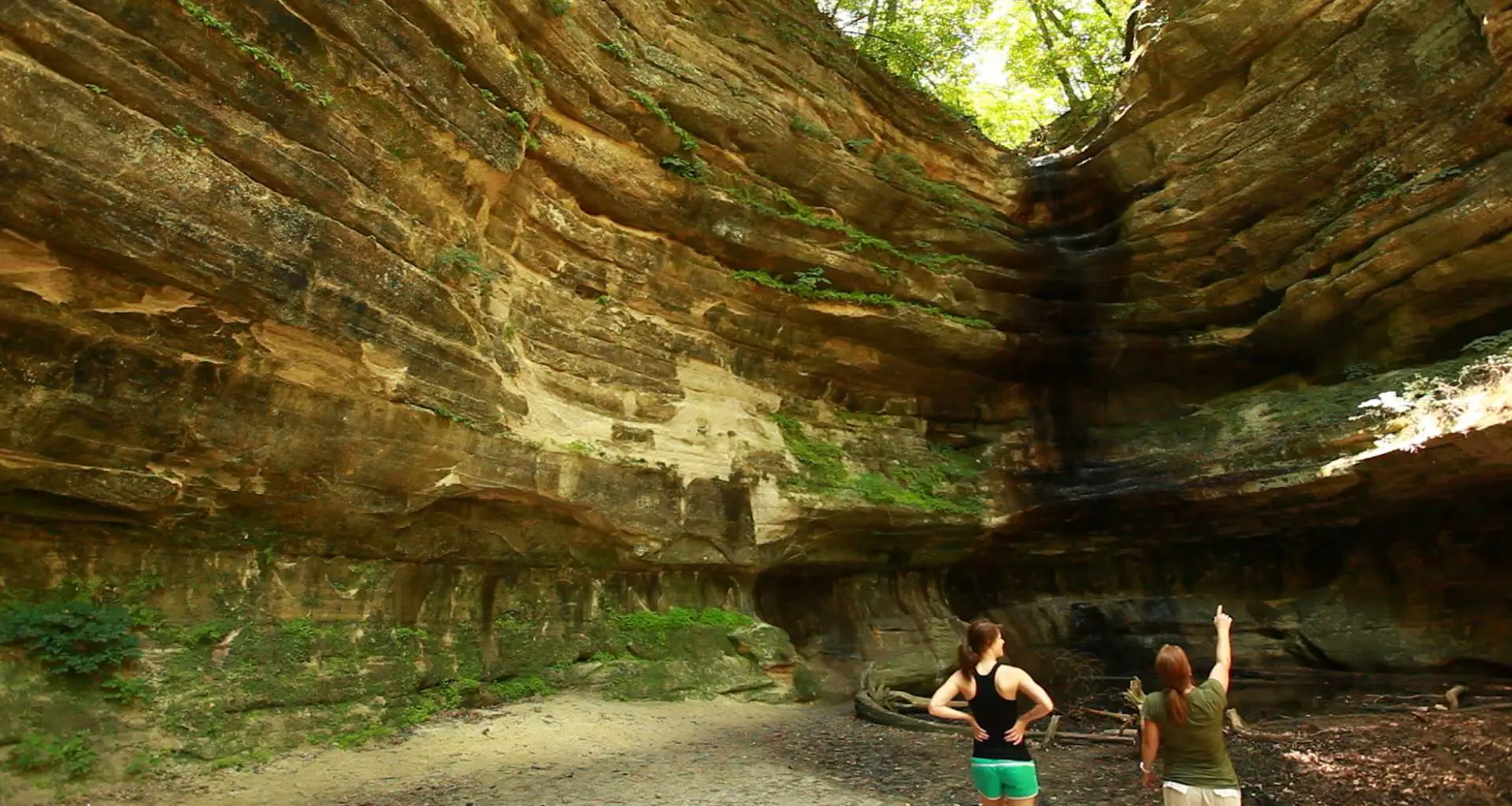 Deux personnes regardant le grand rocher qui les entoure 