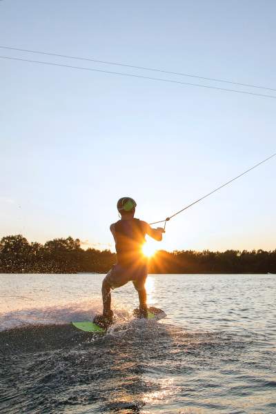 Une personne faisant du wake board au coucher du soleil 