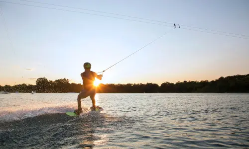 Une personne faisant du wake board au coucher du soleil 