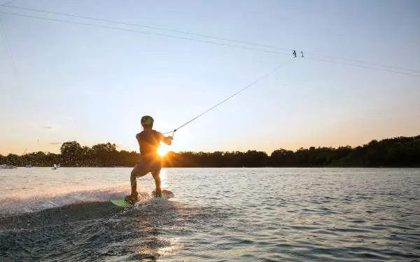 Une personne faisant du wake board au coucher du soleil 