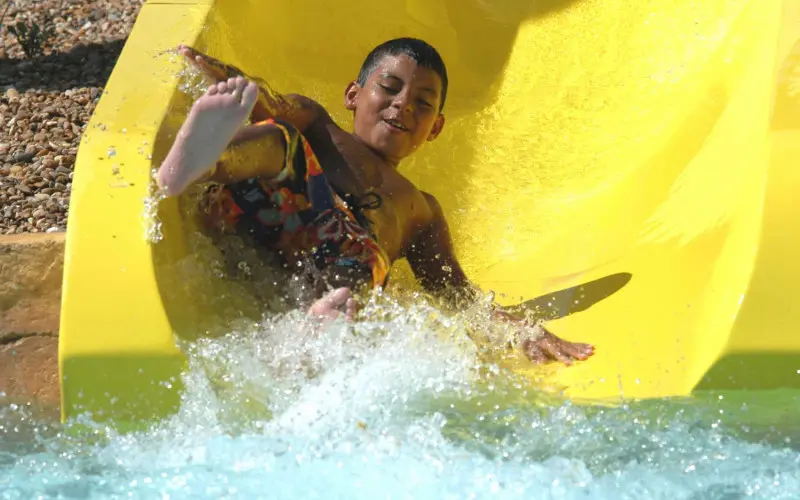 Enfant descendant un toboggan jaune du parc aquatique Great America Hurricane Harbor