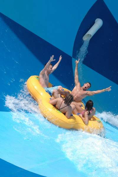 Un groupe de quatre personnes dans un radeau gonflable sur un toboggan aquatique