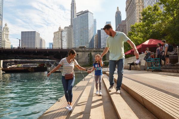 Famille se réveillant au bord d'une rivière avec la ville en arrière-plan