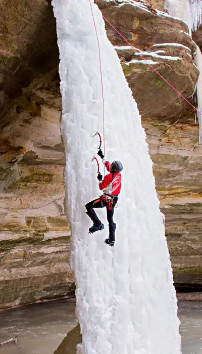 Personne escaladant une cascade de glace