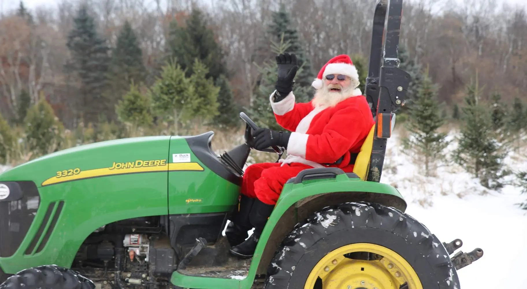 Le Père Noël est assis sur un tracteur