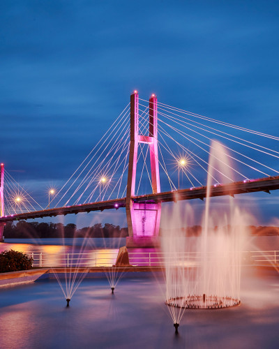 Un pont illuminé avec des fontaines d'eau