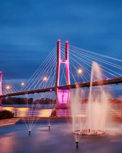 Un pont illuminé avec des fontaines d'eau