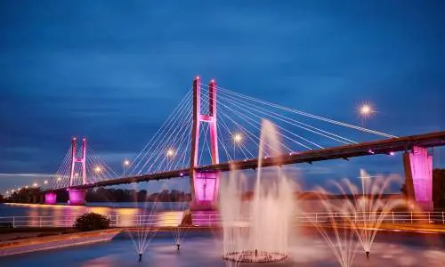 Un pont illuminé avec des fontaines d'eau