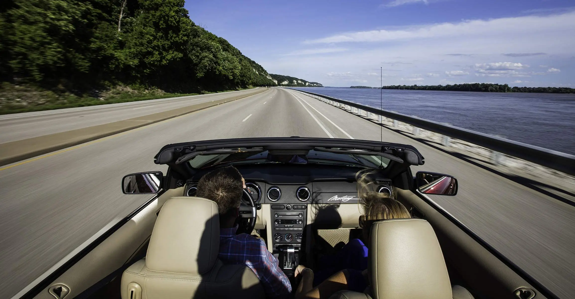 Deux personnes roulant dans une voiture sans toit sur une route