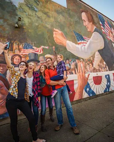 Famille prenant un selfie devant une peinture murale à Ottawa