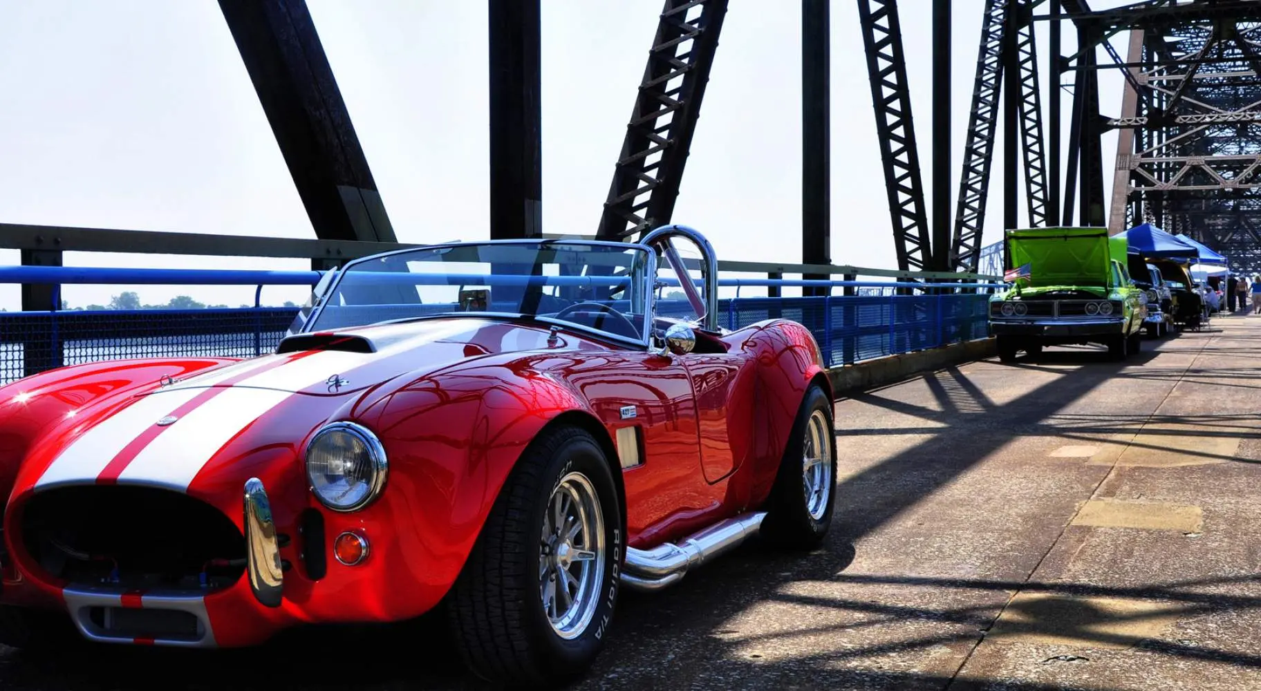 Une voiture de collection rouge garée le long du pont de la chaîne de rochers