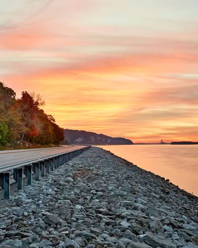 Coucher de soleil sur l'eau et route au bord de la rivière