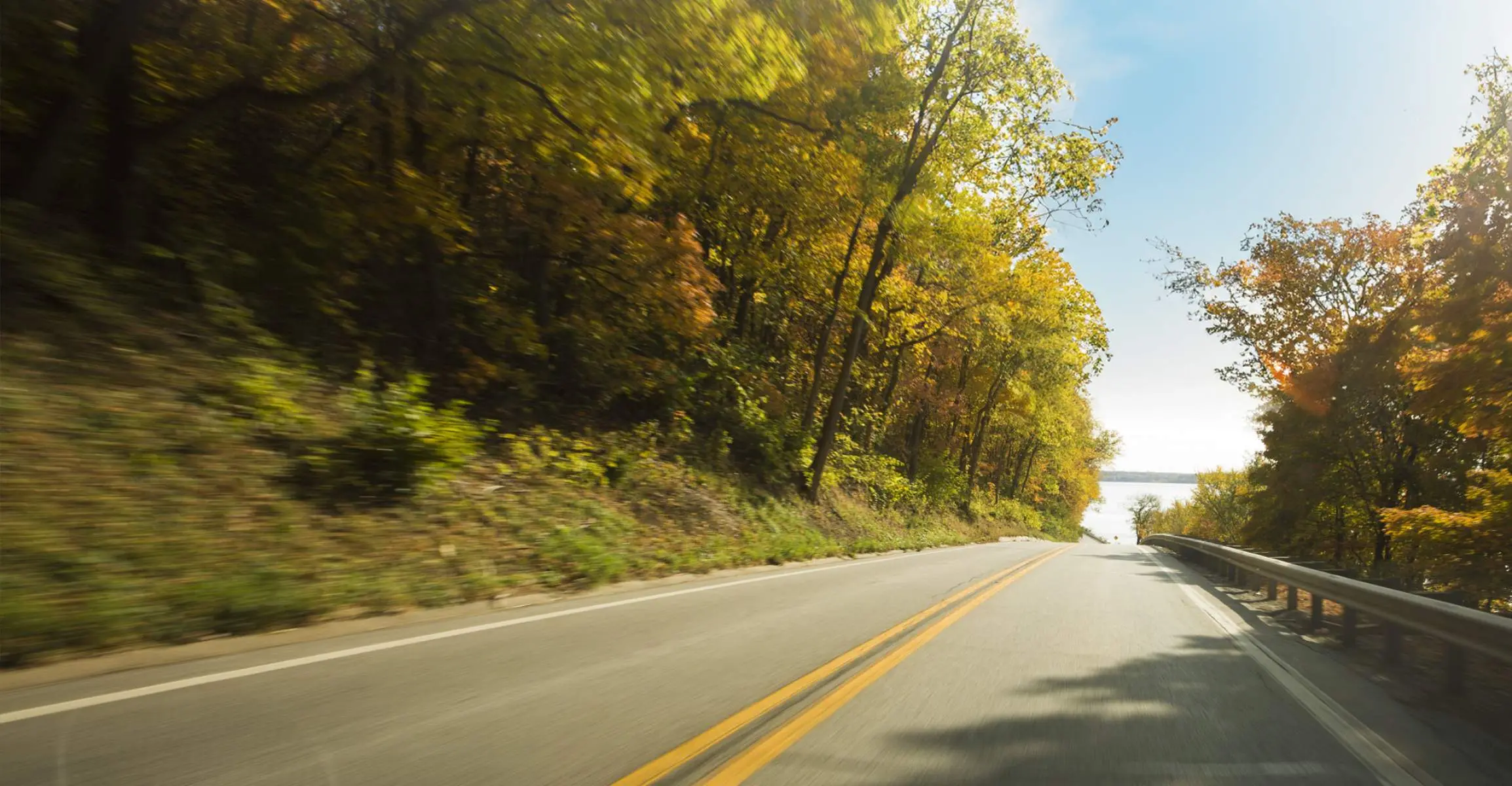Une route entourée de feuillages d'automne