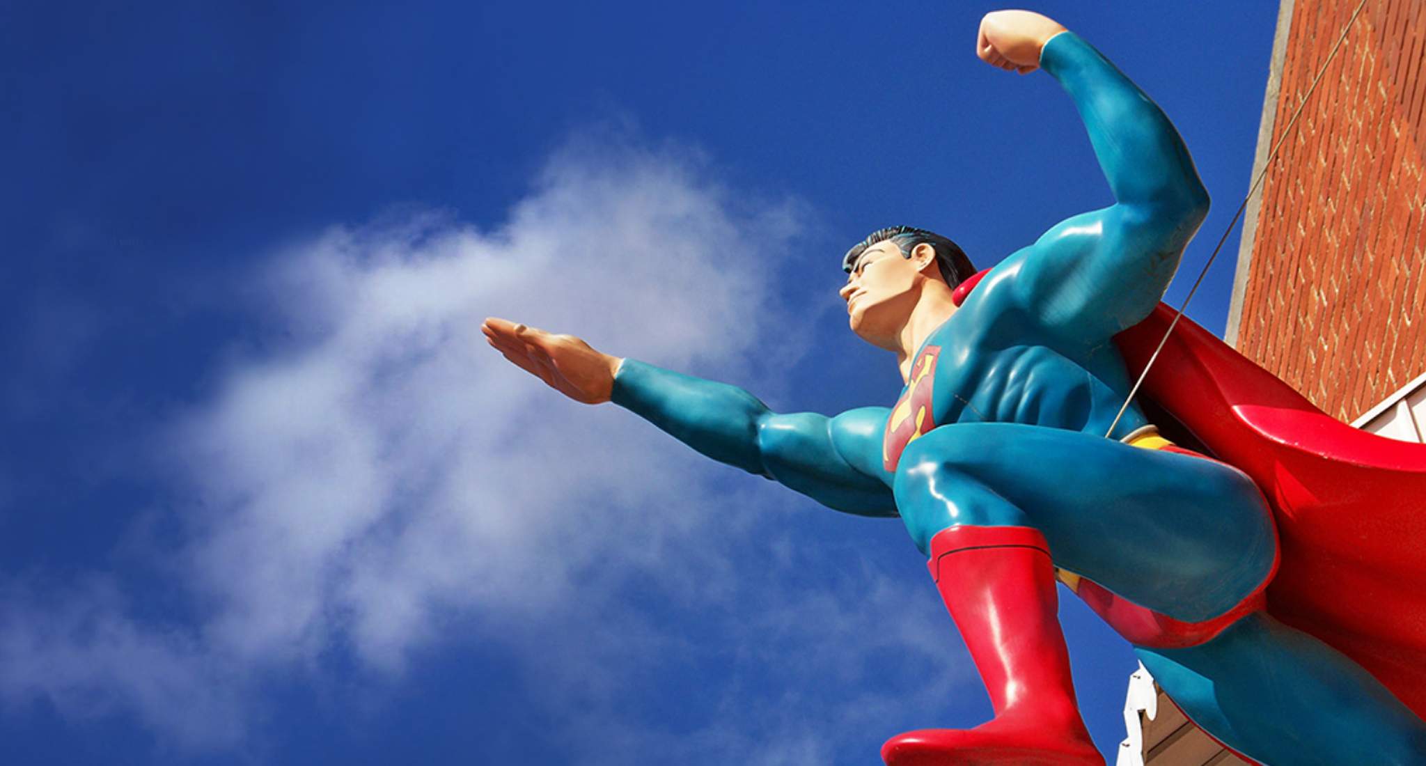 Une statue de Superman sur fond de ciel bleu