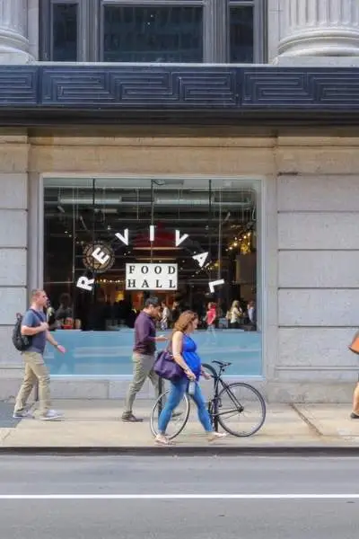 Personnes marchant sur le trottoir le long d'un bâtiment