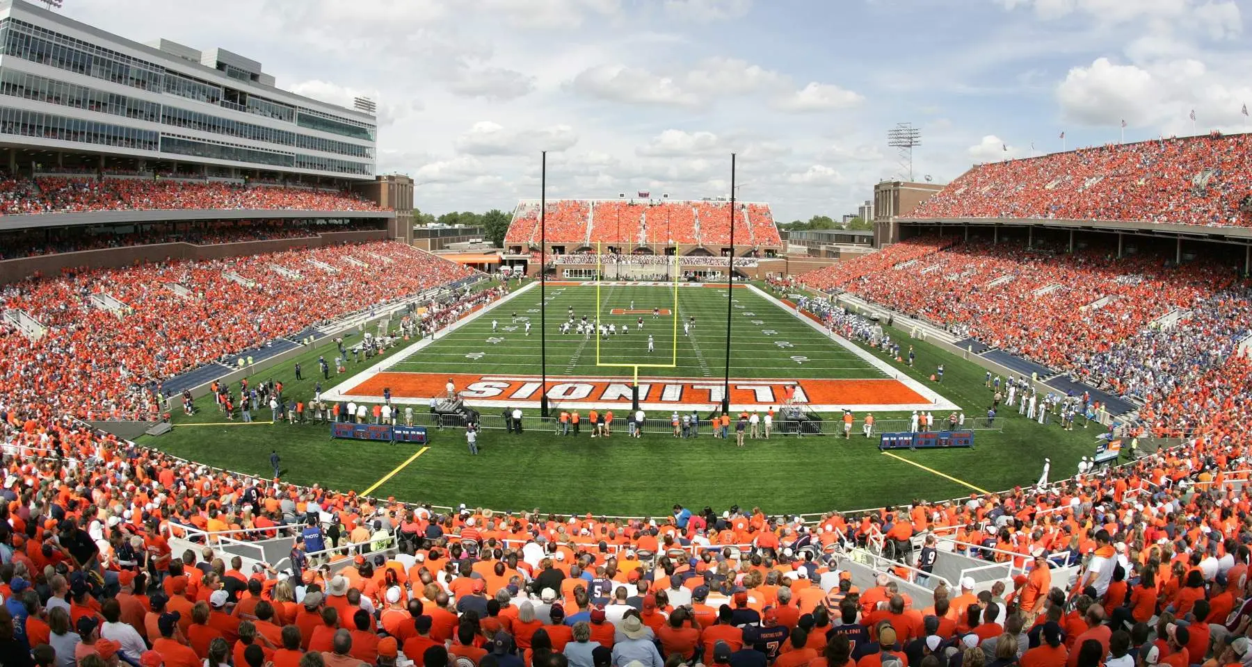 Un stade de football bondé le jour du match, avec de nombreux spectateurs vêtus d'orange