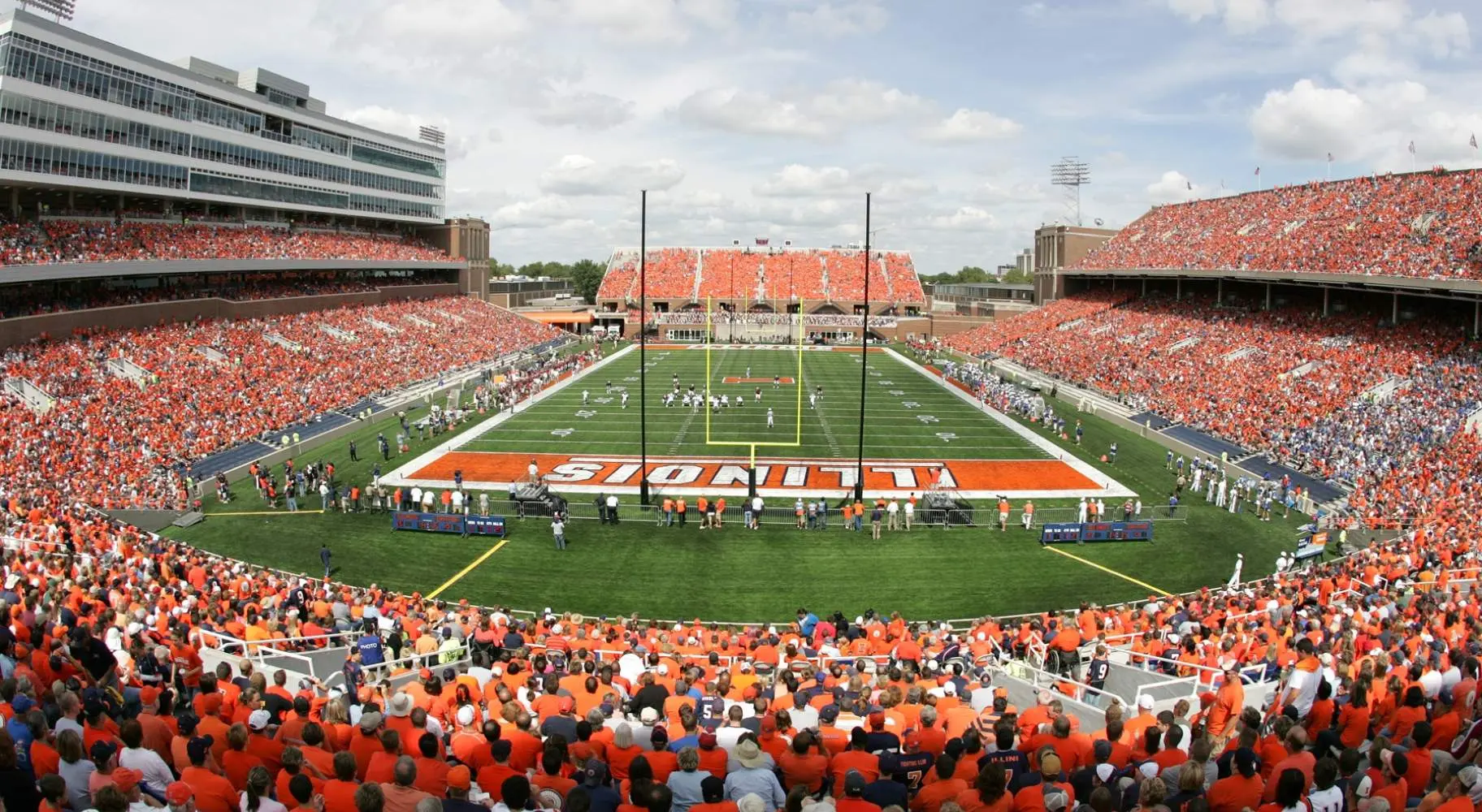 Un stade de football bondé le jour du match, avec de nombreux spectateurs vêtus d'orange