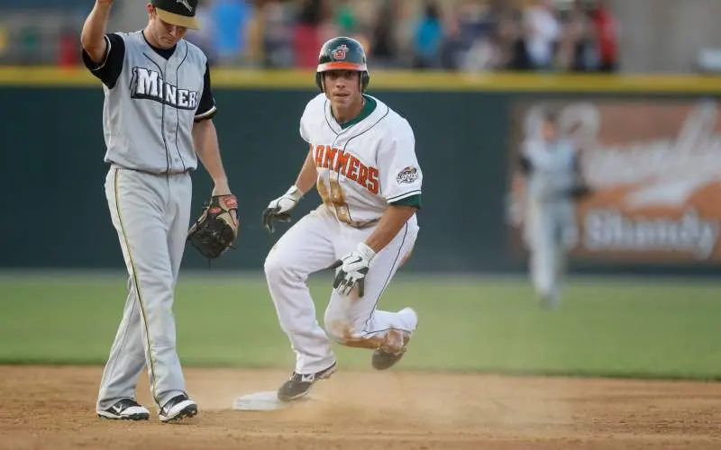 Un joueur de baseball qui court autour du terrain passe une base.
