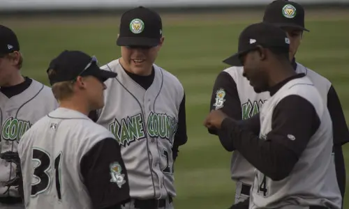 Les joueurs parlent de stratégie lors d'un match des Kane County Cougars
